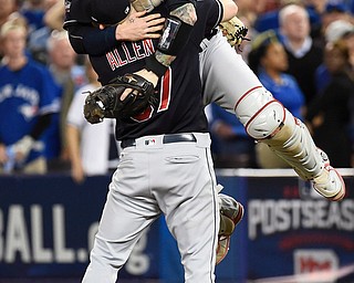 Cleveland Indians relief pitcher Cody Allen (37) and Roberto Perez (55) celebrate the team's 3-0 victory over Toronto Blue Jays during Game 5 of the baseball American League Championship Series, in Toronto on Wednesday, Oct. 19, 2016. (Nathan Denette/The Canadian Press via AP)