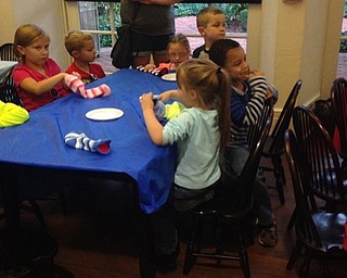 Neighbors | Alexis Bartolomucci.Children used socks to create their own puppets at the Poland library on Sept. 27 after watching the Positively Preposterous Puppet Show.