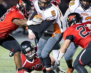 MICHAEL G TAYLOR | THE VINDICATOR- 10-21-16- 1st qtr, Howland's #5 Tyriq Ellis holds on to the ball as  Canfield's #56 Ron Williams makes the tackle. Howland Tigers vs Canfield Cardinals at Bob Dove Field in Canfield, OH.