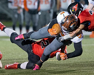 MICHAEL G TAYLOR | THE VINDICATOR- 10-21-16- 1st qtr, Howland's #5 Tyriq Ellis picks up the first down as Canfield's #24 Angelo Petracci (left) and #23 David Crawford make the stop. Howland Tigers vs Canfield Cardinals at Bob Dove Field in Canfield, OH.