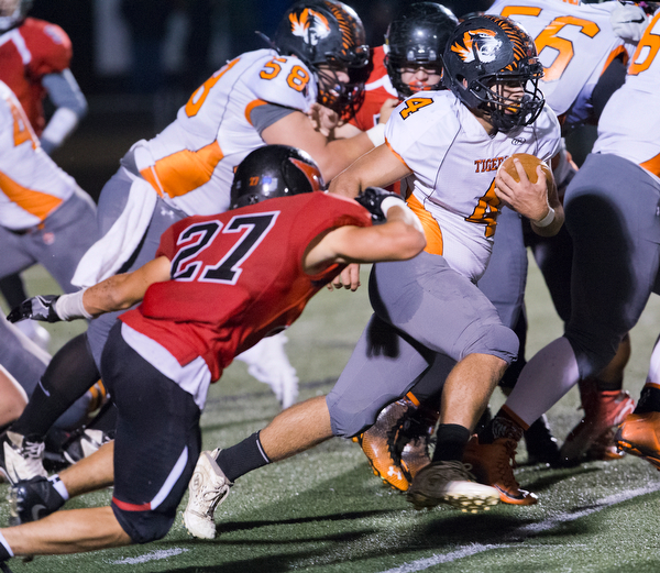 MICHAEL G TAYLOR | THE VINDICATOR- 10-21-16- 2nd qtr, Howland's #4 Jackson Deemer runs for a 1st down as Canfield's #27 Paul French brings him down. Howland Tigers vs Canfield Cardinals at Bob Dove Field in Canfield, OH.