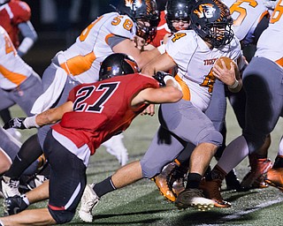 MICHAEL G TAYLOR | THE VINDICATOR- 10-21-16- 2nd qtr, Howland's #4 Jackson Deemer runs for a 1st down as Canfield's #27 Paul French brings him down. Howland Tigers vs Canfield Cardinals at Bob Dove Field in Canfield, OH.
