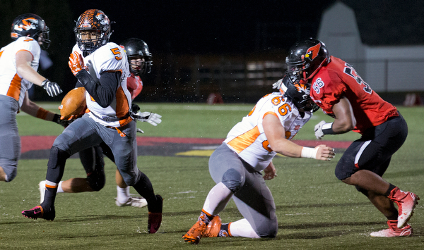 MICHAEL G TAYLOR | THE VINDICATOR- 10-21-16- 1st qtr, on his way to a 31 yard TD run, Howland's #5 Tyriq Ellis cuts behind the block of Howland's #66 Noah Bell on Canfield's #56 Ron Williams. Howland Tigers vs Canfield Cardinals at Bob Dove Field in Canfield, OH.