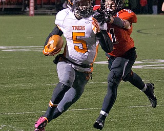 MICHAEL G TAYLOR | THE VINDICATOR- 10-21-16- 1st qtr, on his way to a 31 yard TD run, Howland's #5 Tyriq Ellis breaks the tackle of Canfield's #11 Will Dawson. Howland Tigers vs Canfield Cardinals at Bob Dove Field in Canfield, OH.