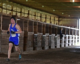 BAZETTA, OHIO - OCTOBER 22, 2016: Andrew Comstock of Poland runs in a horse barn to the finish line during the boy's Division 2 district cross country meet at the Trumbull Country Fairgrounds Saturday afternoon. DAVID DERMER | THE VINDICATOR