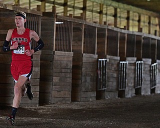BAZETTA, OHIO - OCTOBER 22, 2016: Derek Basinger of Girard runs in a horse barn to the finish line during the boy's Division 2 district cross country meet at the Trumbull Country Fairgrounds Saturday afternoon. DAVID DERMER | THE VINDICATOR