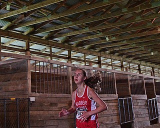 BAZETTA, OHIO - OCTOBER 22, 2016: Miranda Stanhope of Badger sprints to the finish line through a horse barn to the finish line during the girl's Division 3 district cross country meet at the Trumbull Country Fairgrounds Saturday afternoon. DAVID DERMER | THE VINDICATOR
