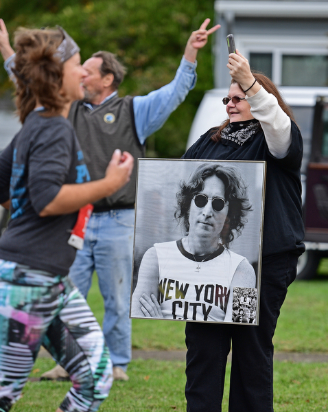 YOUNGSTOWN, OHIO - OCTOBER 23, 2016: Jen Hill of Youngstown holds a picture of John Lennon while recording the start of the Peace Race on her phone Sunday morning. DAVID DERMER | THE VINDICATOR