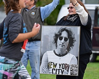 YOUNGSTOWN, OHIO - OCTOBER 23, 2016: Jen Hill of Youngstown holds a picture of John Lennon while recording the start of the Peace Race on her phone Sunday morning. DAVID DERMER | THE VINDICATOR