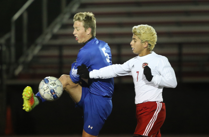 .          ROBERT  K. YOSAY | THE VINDICATOR..Poland #5 Marcus Trevis kicks  the ball from #7  Justin Montazeri  Canfield vs Poland Soccer  District II Semifinals at Canfield..-30-