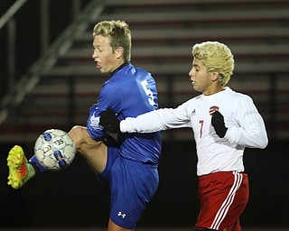  .          ROBERT  K. YOSAY | THE VINDICATOR..Poland #5 Marcus Trevis kicks  the ball from #7  Justin Montazeri  Canfield vs Poland Soccer  District II Semifinals at Canfield..-30-