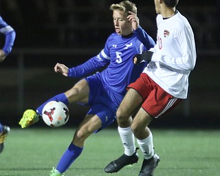  .          ROBERT  K. YOSAY | THE VINDICATOR..Poland #5 Marcus Trevis  keeps the ball moving down field as  #13 Canfield Alec Simone -.Canfield vs Poland Soccer  District II Semifinals at Canfield..-30-