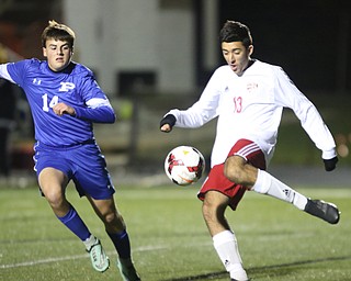  .          ROBERT  K. YOSAY | THE VINDICATOR..#13 Alec Simone takes the ball at midfield  as Poland #14 Marcus Romeo..Canfield vs Poland Soccer  District II Semifinals at Canfield..-30-