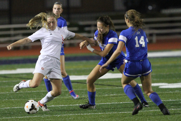 Solon, Ohio: Tuesday, Nov. 1, 2016..Mooney's Caitlin Perry(9) kicks the ball away from Gilmour's defence in the first half as Cardinal Mooney High School takes on Gilmour Academy at the Division III girls soccer regional semifinal at Stewart Field in Solon, Ohio on Tuesday, Nov. 1, 2016...(Nikos Frazier | The Vindicator)..pictured: Gilmour's Alex Siskovic(10) and Grace Mullen(14)