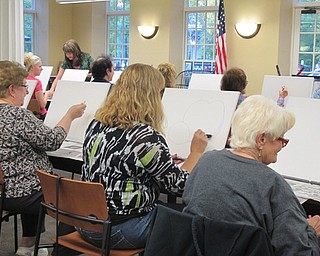 Neighbors | Alexis Bartolomucci.Guests at the Poland library painting event on Oct. 3 worked on sketching out their pumpkins before they painted them.