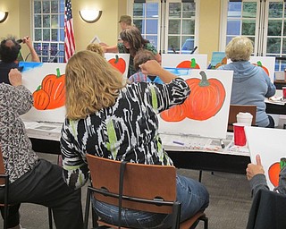 Neighbors | Alexis Bartolomucci.People who attended the painting event at the Poland library on Oct. 3 worked on painting the sky after they finished painting their pumpkins.