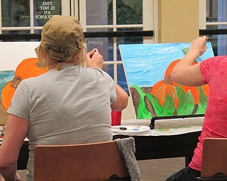 Neighbors | Alexis Bartolomucci.Two guests at the Poland library worked on finishing up their pumpkin paintings during the paint event on Oct. 3.