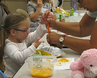 Neighbors | Alexis Bartolomucci.Lynn Zocolo worked with Rylynn to help her push a straw through a raw potato as a science experience during Sprout Club on Oct. 13 at Fellows Riverside Gardens.