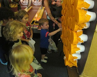 Neighbors | Alexis Bartolomucci.Children pushed their hands through tissue paper to get different treats inside the cup during the Austintown Bounce Halloween party on Oct. 21.