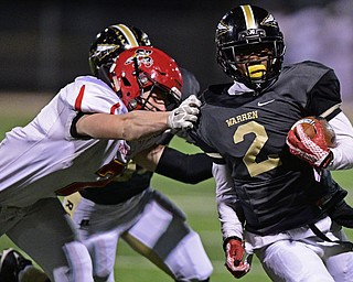 WARREN, OHIO - NOVEMBER 4, 2016: Marlin Richardson #2 of Harding runs down the sideline while being grabbed by Michael Rose #2 of Brecksville-Broadview Heights during the first half of their game Friday night at Warren Harding High School. DAVID DERMER | THE VINDICATOR