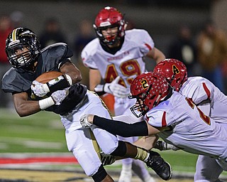 WARREN, OHIO - NOVEMBER 4, 2016: Kayron Adams #33 of Harding falls forward while being tackled by Michael Rose #2 and Victor Bierman #4 of Brecksville-Broadview Heights during the first half of their game Friday night at Warren Harding High School. DAVID DERMER | THE VINDICATOR