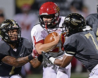 WARREN, OHIO - NOVEMBER 4, 2016: Alec Buckley #20 of Brecksville-Broadview Heights is tackled after a big gain by Lynn Bowden #1 and Naz Batte-Diggs #7 of Harding during the first half of their game Friday night at Warren Harding High School. DAVID DERMER | THE VINDICATOR