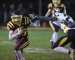             ROBERT  K. YOSAY | THE VINDICATOR..SR #26 Brennan Toy ducks away from Gmen #23 Jarrod Peters as he scampers for a first down..James A Garfield - G-Men  vs South Range Raiders at South Range Stadium..-30-