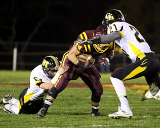             ROBERT  K. YOSAY | THE VINDICATOR..SR #44 Peyton Remish is coraled by Gmen #21 Seth Morgan and  #51 Dane Burrows agter a short gain durning first quarter action..James A Garfield - G-Men  vs South Range Raiders at South Range Stadium..-30-