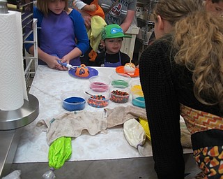 Neighbors | Alexis Bartolomucci.The workers at Sugar Showcase in Austintown helped children decorate their choice of caramel apples or sugar skulls during the edible activity day on Oct. 15.