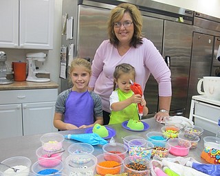Neighbors | Alexis Bartolomucci.McKenzie and Quinn worked on decorating their sugar skulls with their grandmother at the Sugar Showcase in Austintown on Oct. 15.