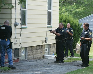 Law enforcement officers prepare to search a house on E Judson after an officer was shot nearby Wed afternoon. WD LEWIS