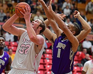 YOUNGSTOWN, OHIO - NOVEMBER 12, 2016: Jorden Kaufman #32 of YSU looks to the basket while being pressured from behind by Josh Williams #1 of Akron during the first half of their game Saturday night the Beeghly Center. DAVID DERMER | THE VINDICATOR