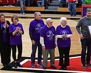 YOUNGSTOWN, OHIO - NOVEMBER 12, 2016: Nancy Peters holds a plaque in honor her husband and former YSU men;s basketball coach Dan Peters while standing with their sons Danny, right, and Michael, left, and their extended family at halftime of Saturday nights game. DAVID DERMER | THE VINDICATOR
