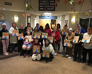 Neighbors | Alexis Bartolomucci.Guests who attended the Paint and Taste event at Beeghly Oaks on Oct. 14 held up their finished owl paintings.