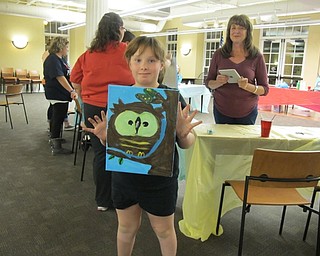 Neighbors | Alexis Bartolomucci.Shayla Mozingo held up her finished owl painting during the Poland library Halloween Painting party on Oct. 13.