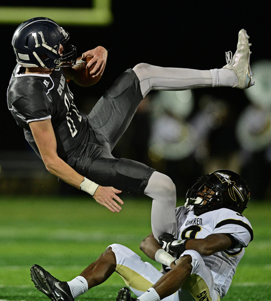 TWINSBURG, OHIO - NOVEMBER 18, 2016: Jackson Parker #11 of Hudson flies through the air while being grabbed by Juvar King #9 of Harding during the first half of their playoff game Friday night at Twinsburg High School. DAVID DERMER | THE VINDICATOR