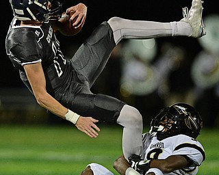 TWINSBURG, OHIO - NOVEMBER 18, 2016: Jackson Parker #11 of Hudson flies through the air while being grabbed by Juvar King #9 of Harding during the first half of their playoff game Friday night at Twinsburg High School. DAVID DERMER | THE VINDICATOR