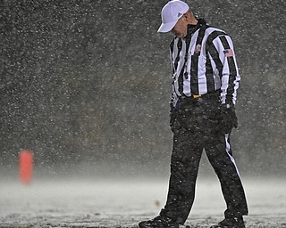 STRONGSVILLE, OHIO - NOVEMBER 19, 2016: Head referee Brad Hutley braces himself during a strong gust of wind in the snow during the first half of a game between Warren JFK and Norwalk St. Paul Saturday night at Strongsville High School. DAVID DERMER | THE VINDICATOR