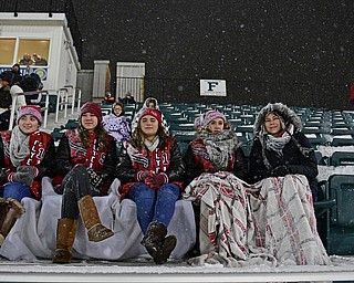 STRONGSVILLE, OHIO - NOVEMBER 19, 2016: Norwalk St. Paul students sit in the bleachers in a snow storm during halftime of a game between Warren JFK and Norwalk St. Paul Saturday night at Strongsville High School. DAVID DERMER | THE VINDICATOR