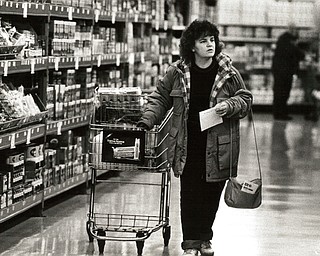November 26, 1986 -- Shopping and saving top list of pre-Thanksgiving tasks..A few last items: Despite long and thoughtful preparations for Thanksgiving Day, there are always a few forgotten items that need to be purchased. Micky Hafely of Austintown checked her shopping list Wednesday as she strolled down an aisle at CarlÕs Food and Drug Warehouse Supermarket at 5220 Mahoning Ave., Austintown. (The Vindicator/ Bob DeMay)