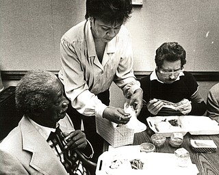 November 26, 2016 -- Feast, tour provided at Packard..About 15 residents of the North Manor Center nursing home in Youngstown not only were treated to a Thanksgiving Day feast Wednesday, they also got a tour of Packard ElectricÕs Thatcher Lane plant in Austintown as part of an event sponsored by the company and the union. Olivette Nevels, a Packard employee, helped North Manor resident Johnny Stewart, left, with his dinner, while James Harmon dined. (The Vindicator/ William D. Lewis)