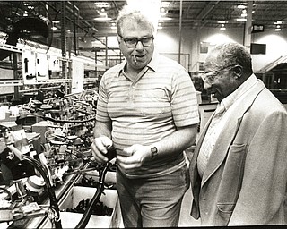 November 26, 2016 -- Feast, tour provided at Packard..About 15 residents of the North Manor Center nursing home in Youngstown not only were treated to a Thanksgiving Day feast Wednesday, they also got a tour of Packard ElectricÕs Thatcher Lane plant in Austintown as part of an event sponsored by the company and the union. Assembly line worker Dave Spellick explained his job to Robert Dancie, who worked on the line at a General Motors facility in Euclid for 43years before retiring in 1983. (The Vindicator/ William D. Lewis)