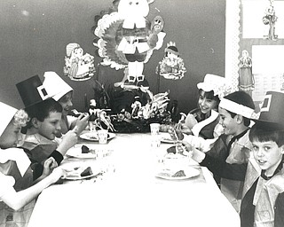 November 22, 1986 Ñ Austintown fourth-graders enjoy early Thanksgiving..Thanksgiving came early to Woodside Elementary School in Austintown as a feast was prepared on Friday for the three fourth-frade classes there. In proper costume for dinner are, from left: Michele Pfund, John Vavrinak, Jennifer Guidosh, Angie Blakeman, Dan Napolitan and Eric Lloyd. (The Vindicator/ Lloyd S. Jones)