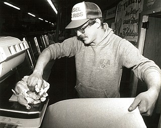 November 26, 1986 -- Poultry in the pan and the soup will make holiday diners happy..Curtis Wilson, manager of the Pyatt Street Market, prepares to wrap soup chickens that probably will be used in a customerÕs wedding or chicken soup that are very popular during the holidays. (The Vindicator/ Patricia L. Fife)