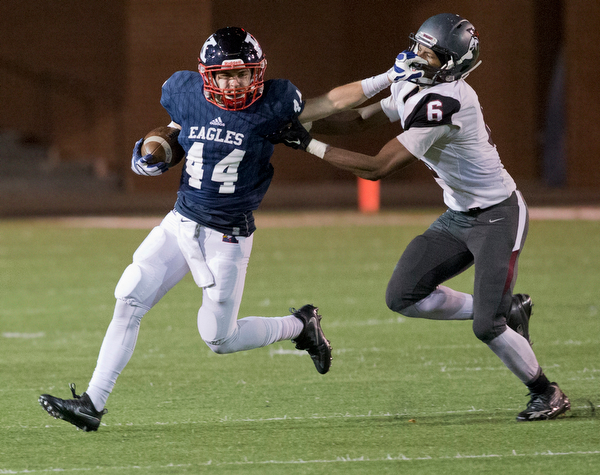 MICHAEL G TAYLOR | THE VINDICATOR- 11-26-16- 3rd qtr, JFK's #44  Jacob Coates stiff arms Canal Preps' Daquan Owens-Johnson on his way to a 1st down. OHSAA D7 Football Semi  John F Kennedy Eagles vs Canal Winchester Harvest Prep Warriors at Woody Hayes Quaker Stadium in New Philadelphia, OH.