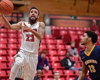 YOUNGSTOWN, OHIO - NOVEMBER 26, 2016: Francisco Santiago #23 of YSU goes to the basket while Isaiah Reese #13 of Canisius watches during the first half of their game Saturday afternoon at the Beeghly Center. DAVID DERMER | THE VINDICATOR