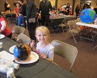 Neighbors | Alexis Bartolomucci.Ava worked on painting her pumpkin during the West Side Cats Halloween Spook-tacular on Oct. 21 at Austintown Park.