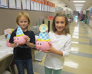Neighbors | Alexis Bartolomucci.Second-graders Morgan Brammer and Genevieve Majcejko held up the pig pumpkins they decorated during school at Poland Union Elementary.