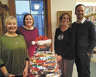 Leetonia Community Public Library recently welcomed Christopher Simmons as a new employee. Joan Clunen and Linsday Kuzemchak created a book tree to decorate for the holidays. The library will host Santa at 5 p.m. Saturday after he rides into Wick Park on a fire truck to light the tree. Cookies and cocoa will be served during Santa’s visit by Friends of the Library. From left are Clunen, Kuzemchak, Judy Kiliany and Simmons. SPECIAL TO THE VINDICATOR