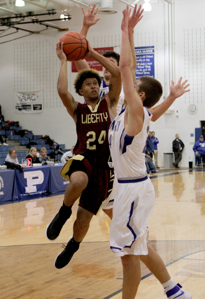 Liberty's Capone Haywood (24) drives to the hoop while being defended by Poland's Billy Orr (24) during the first half of Friday nights matchup at Poland Seminary High School.  Dustin Livesay  |  The Vindicator  12/3/16  Poland